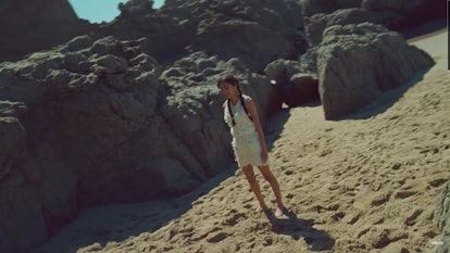 Olivia Rodrigo on the beach in the "Deja Vu" music video.