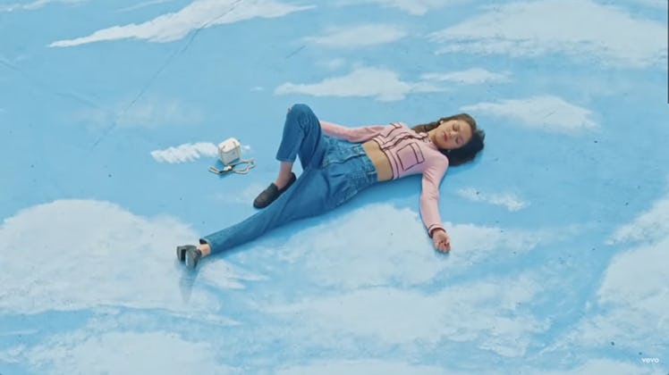 Olivia Rodrigo laying in the sky in the "Deja Vu" music video.