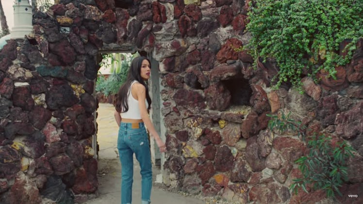 Olivia Rodrigo in jeans and a tank top in the "Deja Vu" music video.