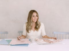 Lauren Conrad sits at a table looking at swatches for Amazon Handmade.