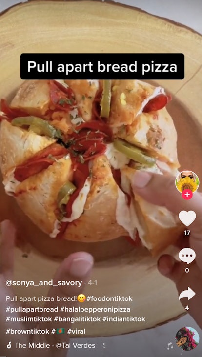 A woman pulls apart a jalapeño and pepperoni pull apart pizza bread. 