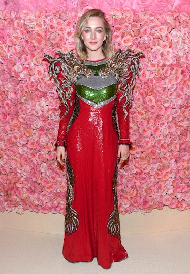 Saoirse Ronan posing in a Gucci red gown at The 2019 Met Gala Celebrating Camp