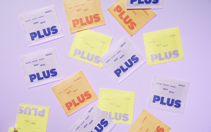 A selection of PLUS packages are laid out against a purple backdrop