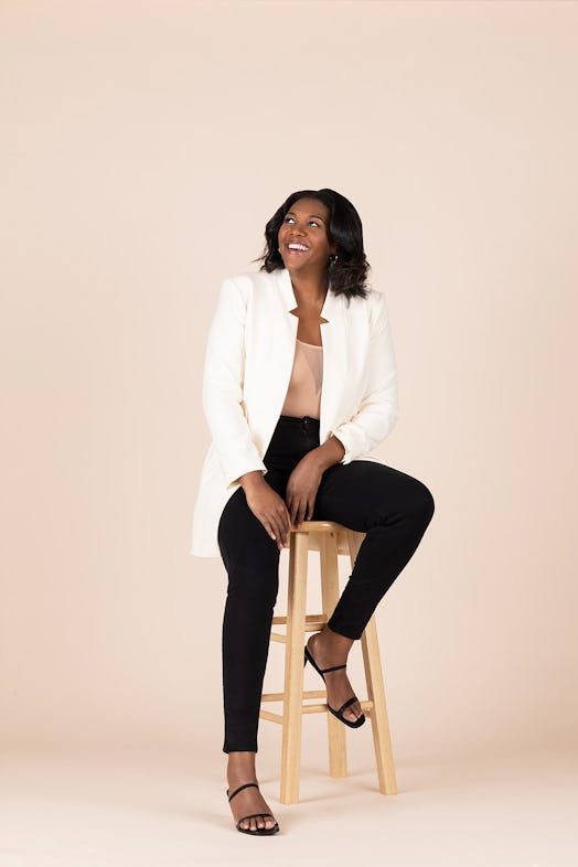 Founder of Glory Skincare Alisia Ford sits on a stool.