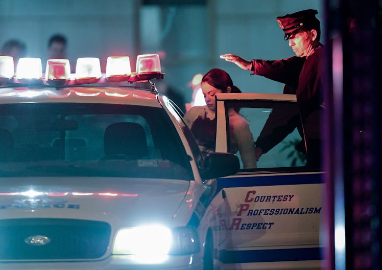 Selena Gomez ducking into a police car