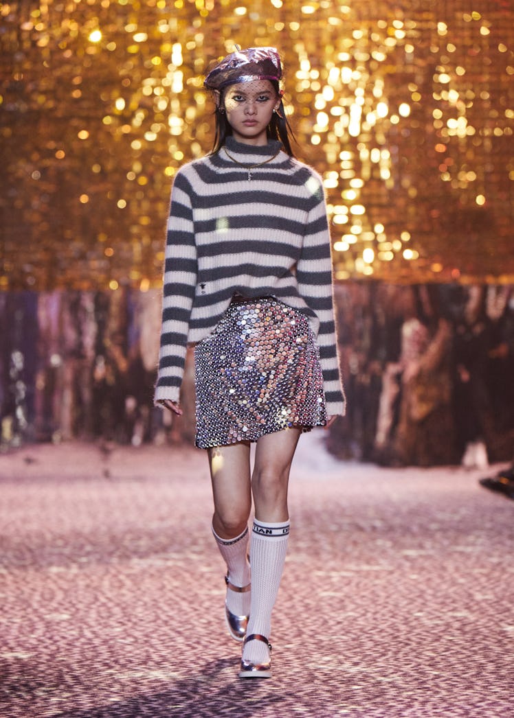 A model walking the runway in a sequined mini skirt and striped turtleneck at Chrisitan Dior Pre-Fal...