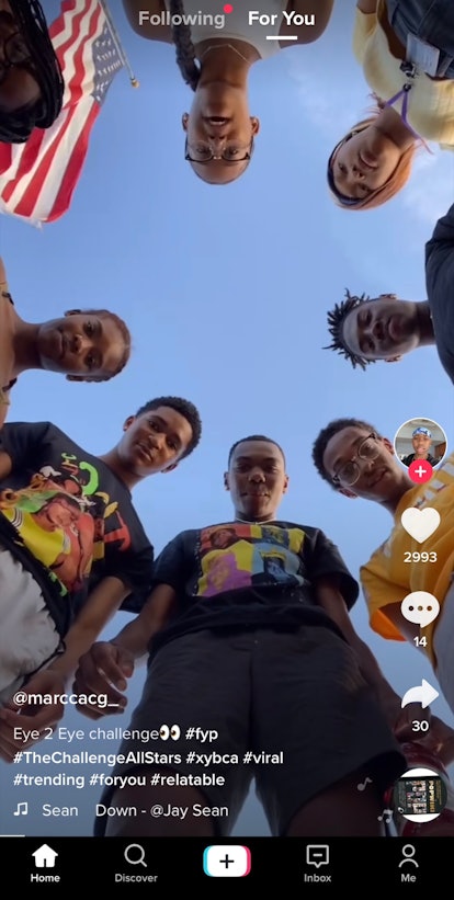 A group of friends plays the eye-to-eye challenge on TikTok while hanging outside on a sunny day.