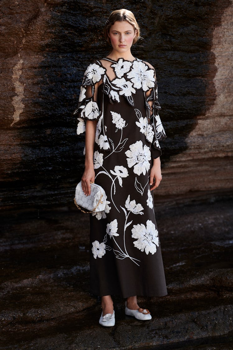 A model posing in a black-and-white floral patterned dress from Tory Burch's pre-fall 2021 collectio...