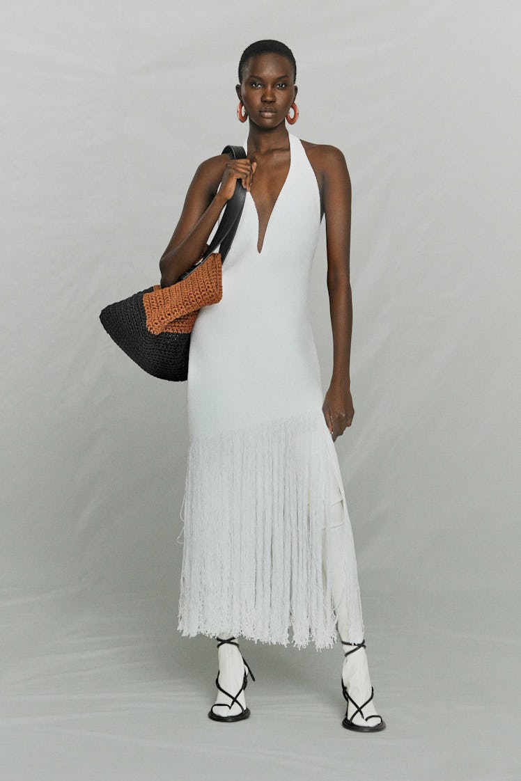 A model posing in a white fringed dress from Proenza Schouler's pre-fall 2021 collection