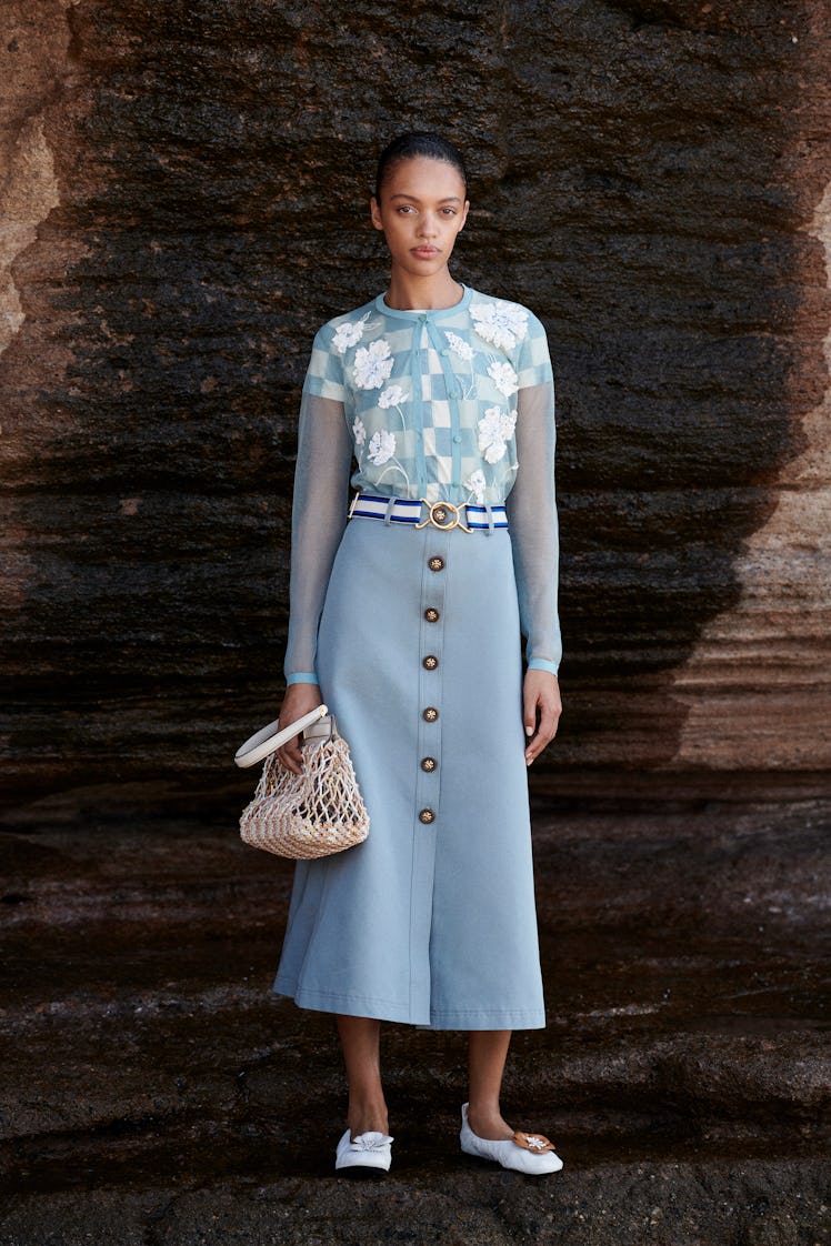 A model posing in a light blue dress from Tory Burch's pre-fall 2021 collection