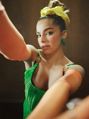 TikTok star Addison Rae wears a green outfit as she takes a selfie for Bustle's cover.