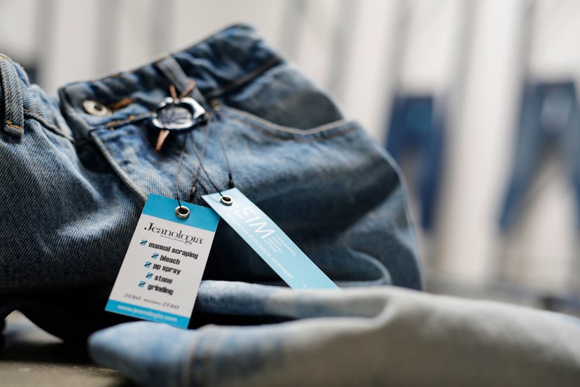 A close-up of  a pair of Jeanologia blue denim jeans with the a blue-white tag