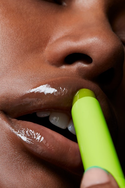 model applies mac cosmetics squirt balm to lips