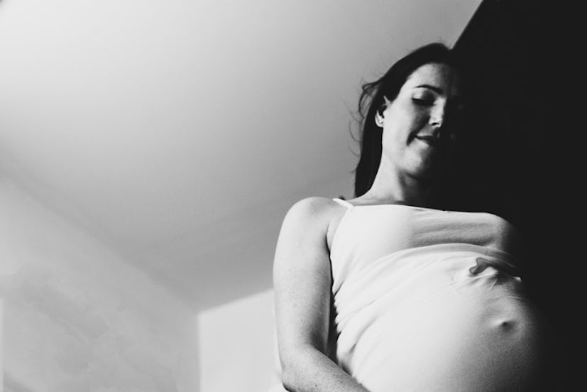 Low Angle View Of Pregnant Woman Standing Against Ceiling