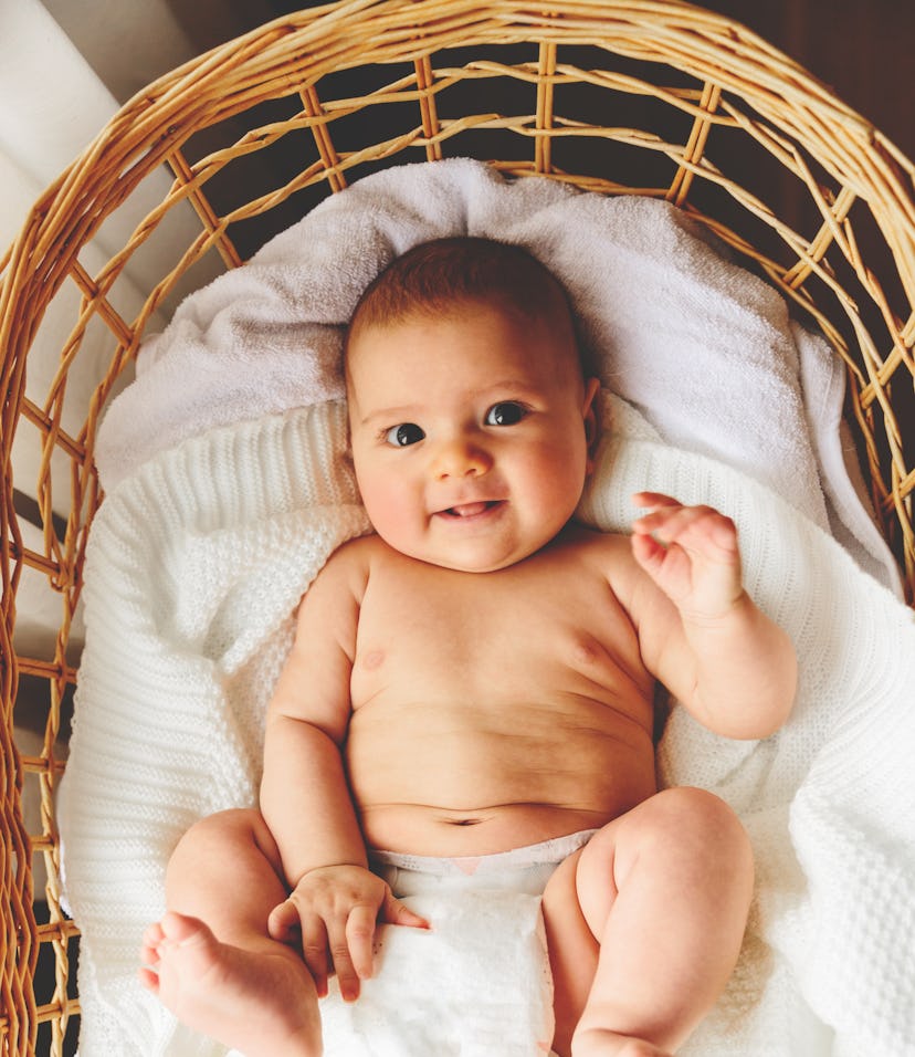 baby lying in wicker bassinet