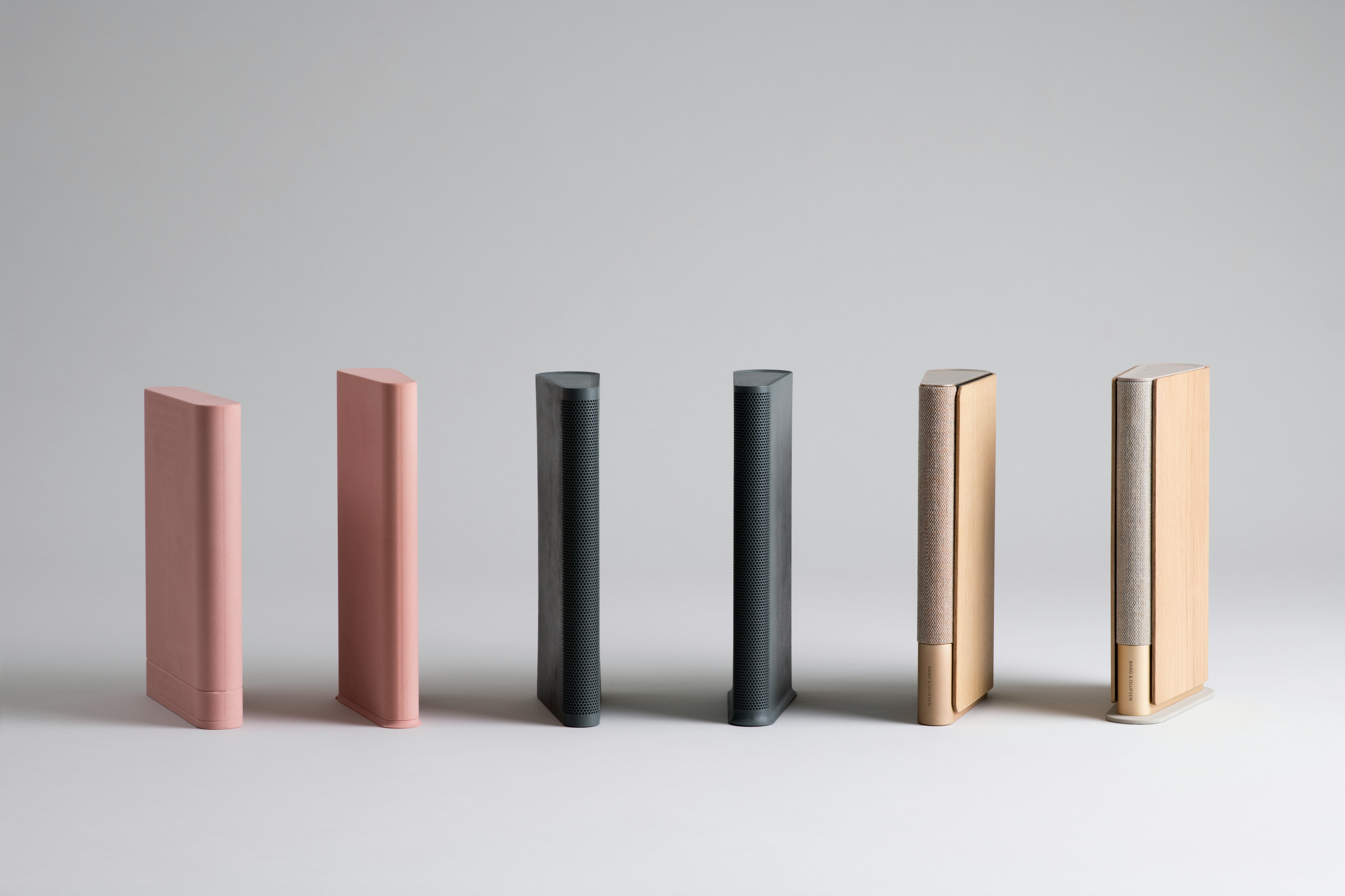 Lean speakers in golden and black tones by Bang and Olufsen. The pink ones are size models.