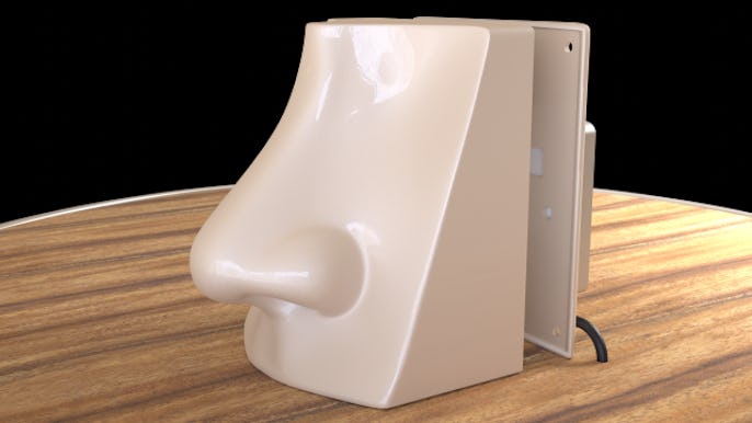 A fake nose powered by AI is seen on a desk surface. The nose is beige.