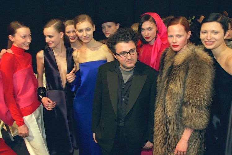 Alber Elbaz posing next to a group of model backstage at a fashion show