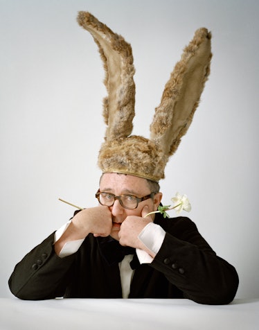 Alber Elbaz with a hat with giant rabbit ears holding a white flower