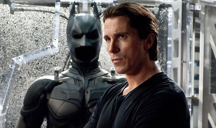 Christian Bale as Bruce Wayne by his batsuit in The Dark Knight