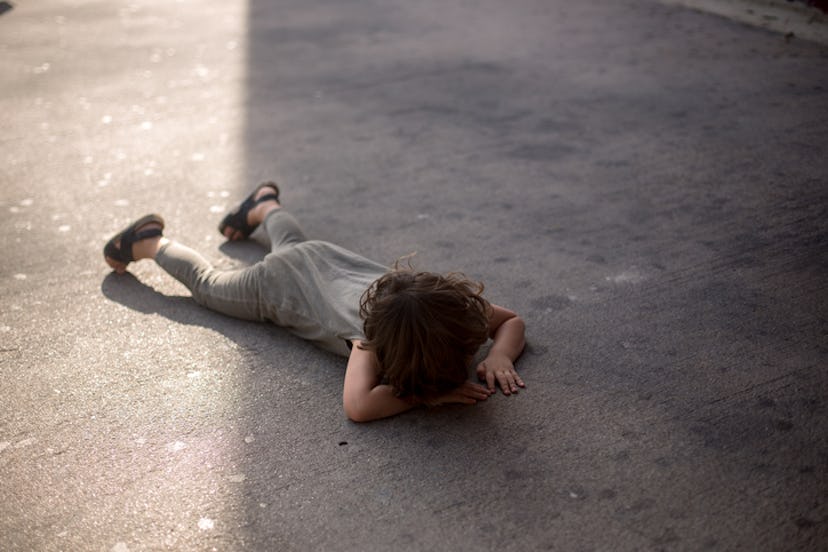 child having a tantrum on the sidewalk