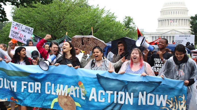 A group of climate activists protesting in favor of action against climate change and holding a blue...