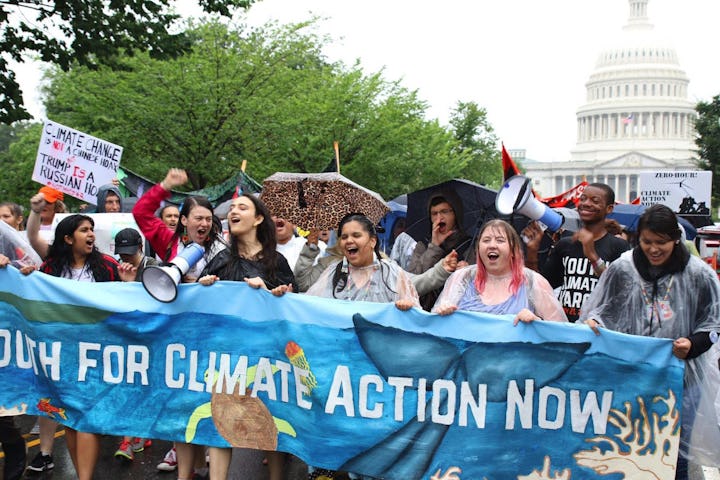 A group of climate activists protesting in favor of action against climate change and holding a blue...