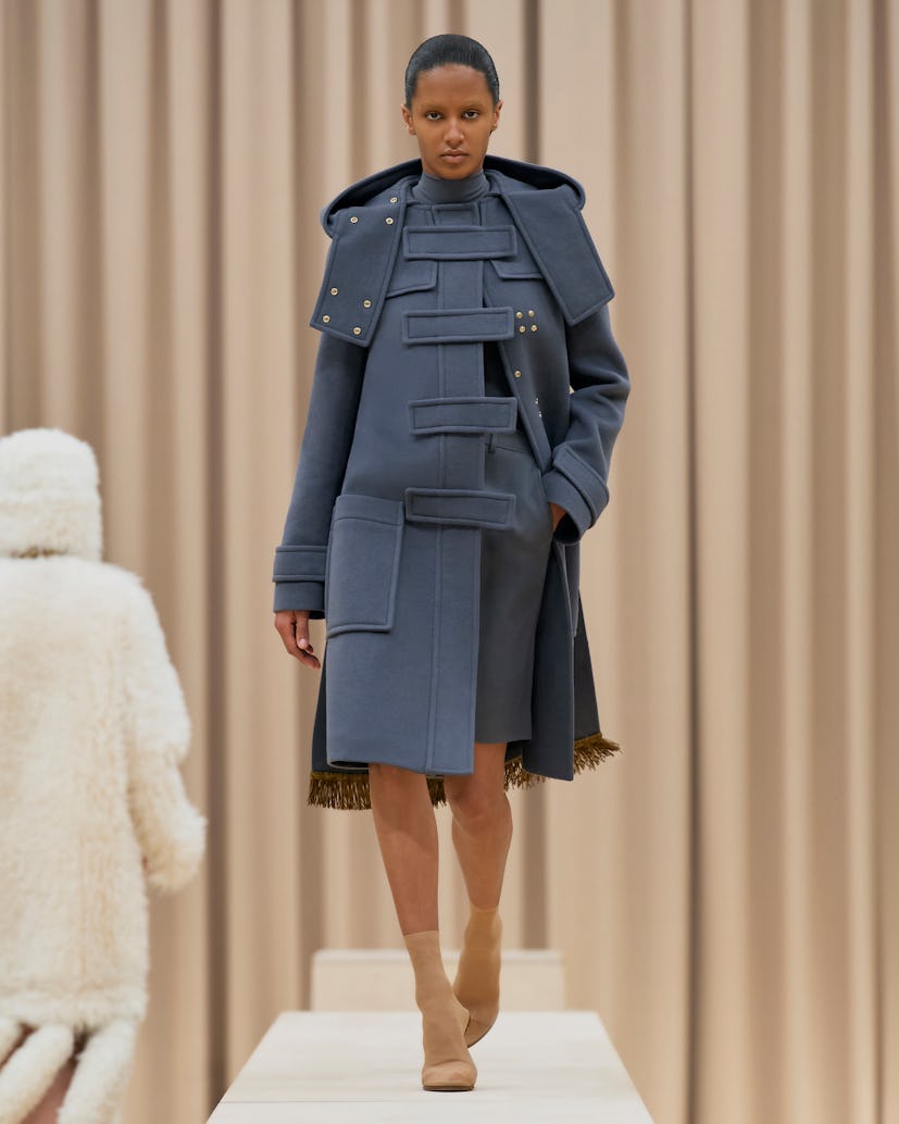 Model walks in Burberry's Fall/Winter 2021 show in a blue trench coat.