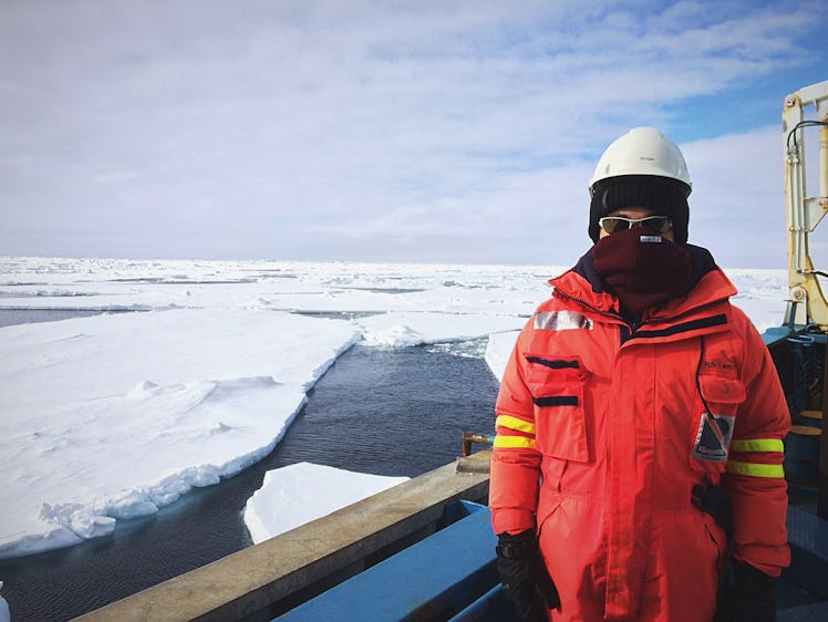 Zachary Labe in protective gear while standing on a boat going through ice fields