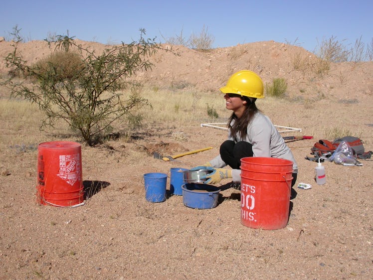 Lydia Jennings in protective gear crouching in a desert