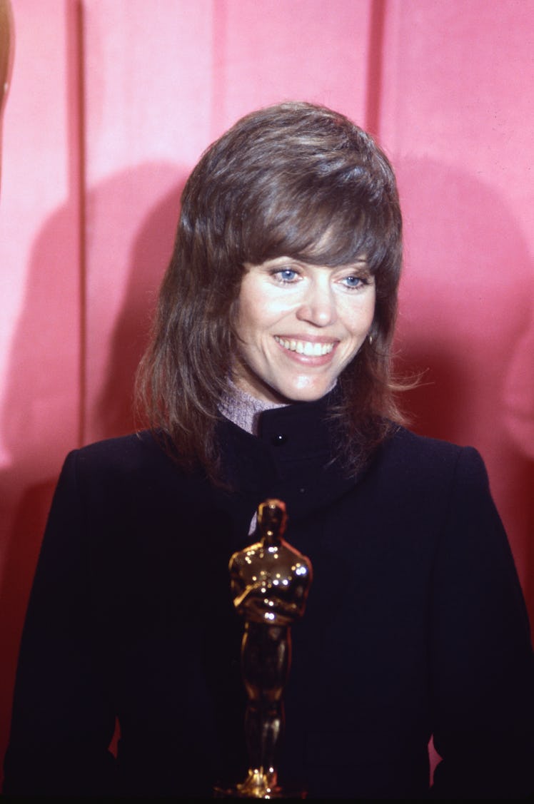 Jane Fonda wearing a Klute haircut and dark blazer, holding an Oscar
