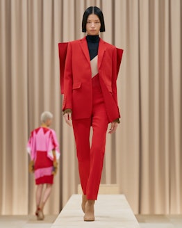 Model walks in Burberry's Fall/Winter 2021 show wearing a red suit.
