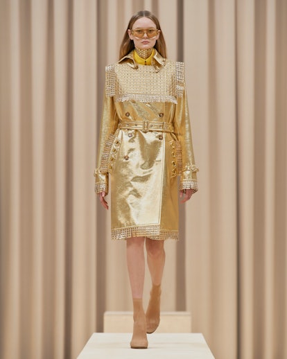 Model walks in Burberry's Fall/Winter 2021 show in an all gold outfit. 