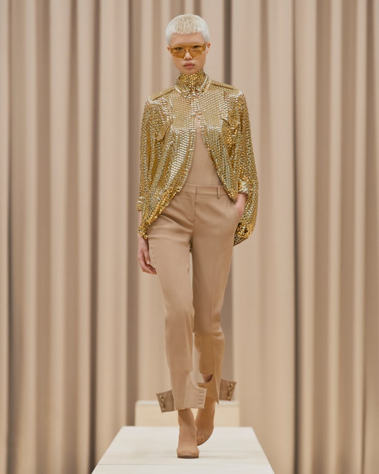 A model in a Burberry gold sequin top and beige pants at the London Fashion Week