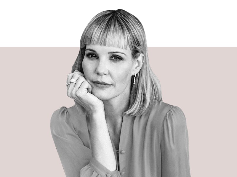 Leslie Bibb sitting and resting her head in her hand while looking at the camera