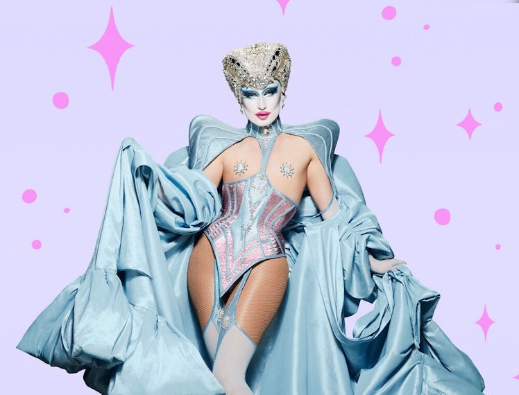 Gottmik in a sating blue corset and cape outfit with a silver crown hat