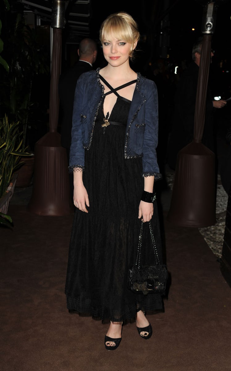 Emma Stone in a black dress and navy jacket at Chanel’s Pre-Oscars Dinner