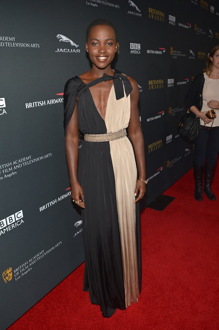 Lupita Nyong’o at a BAFTA event in a beige-black dress by Alber Elbaz in 2013