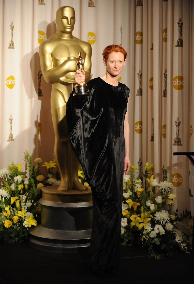 Tilda Swinton holding an Oscar in a black gown by Alber Elbaz in 2008