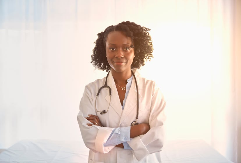Black female doctor posing for a photo in a doctor's uniform