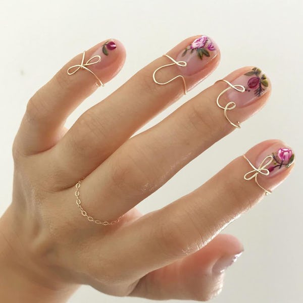 Flower-painted nails with gold nail rings by Betina Goldstein