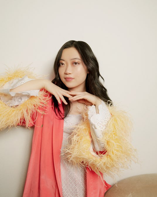Olivia Cheng in a yellow and pink shirt with feathered sleeves 