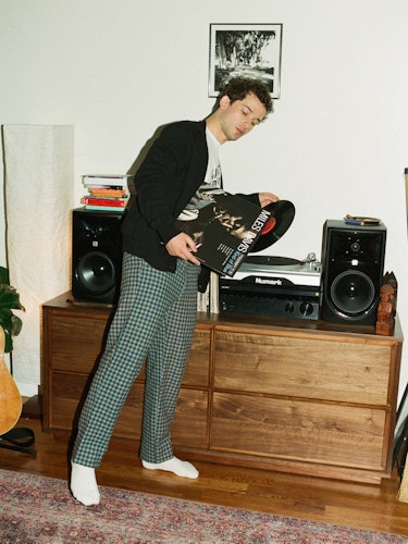 Eli Brown in black sweater, Celine shirt, with records
