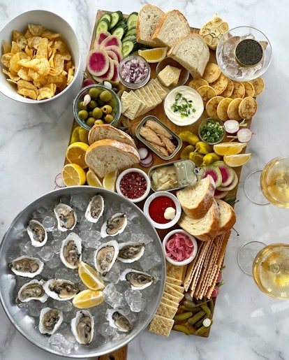 Grazing board with oyster, bread, vegetables, and caviar