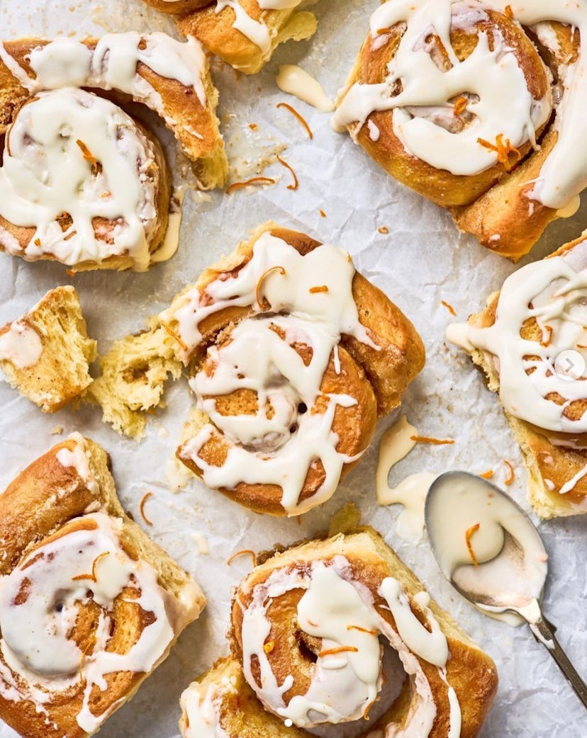 Close-up of orange mimosa cinnamon rolls with icing drizzled on top