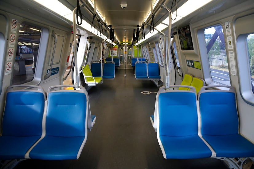 The inside of an empty train car with blue seats during the pandemic