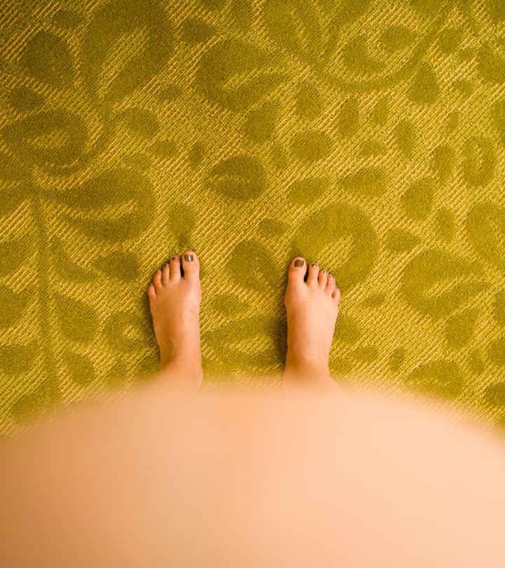 birds eye view of feet with pregnant belly bump in the foreground