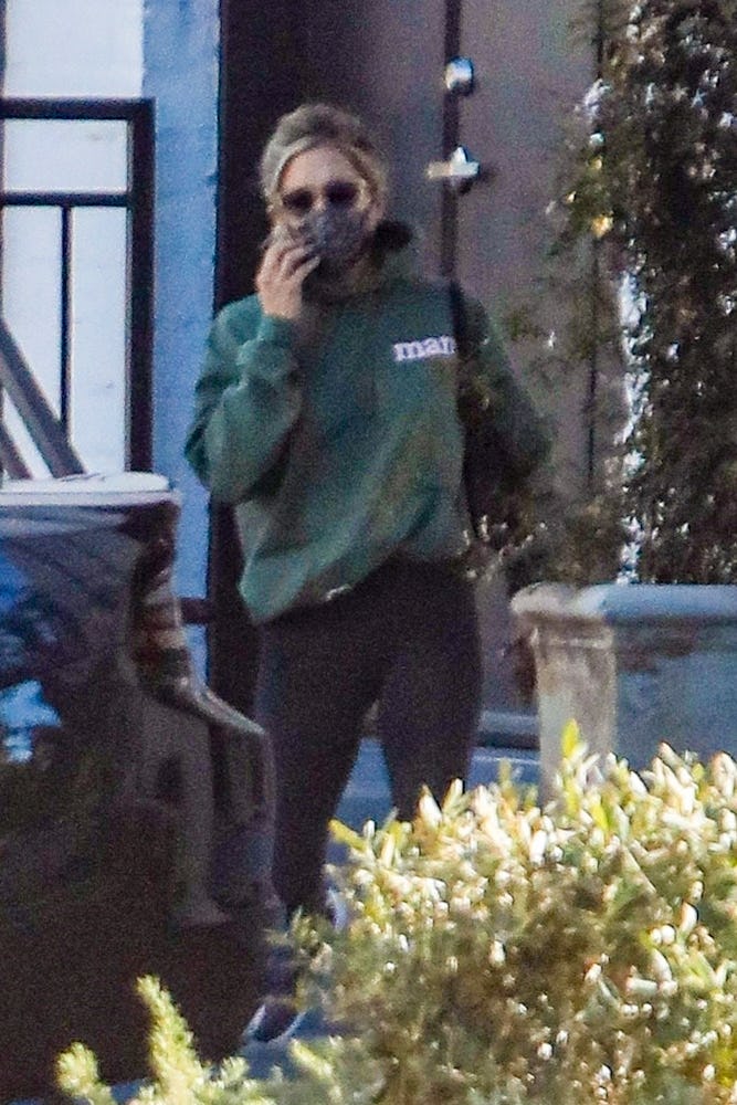 Jennifer Aniston covers her face with a mask while leaving a skincare salon in Beverly Hills with he...