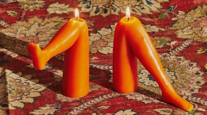 orange wax bent leg candles with wicks on the knees