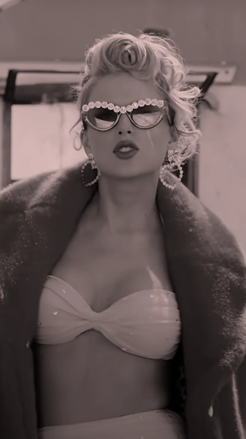 Taylor Swift wears a pink fuzzy jacket and a matching bikini top in her "You Need To Calm Down" vide...
